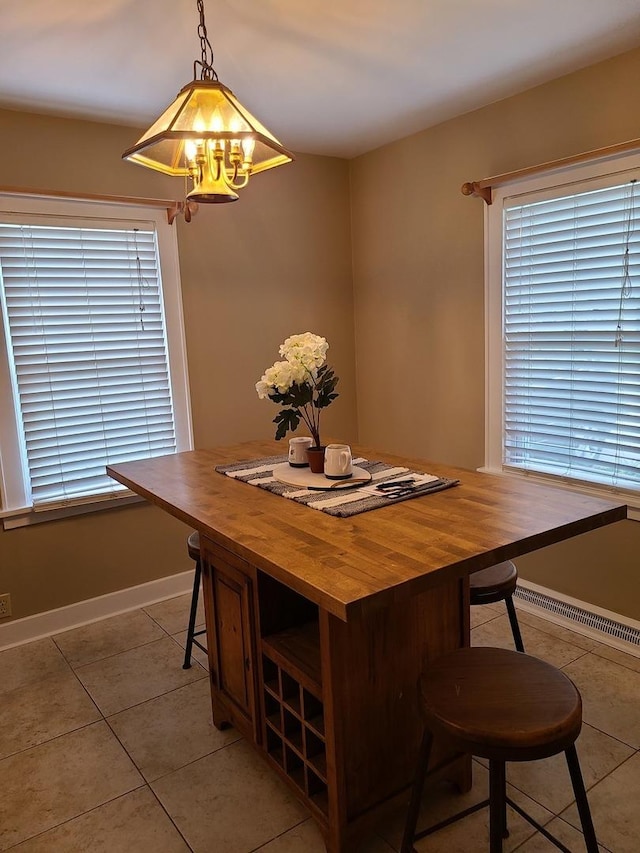617 E Morgan St, Dixon, IL 61021 - dining space featuring light tile patterned floors, a chandelier, and baseboards