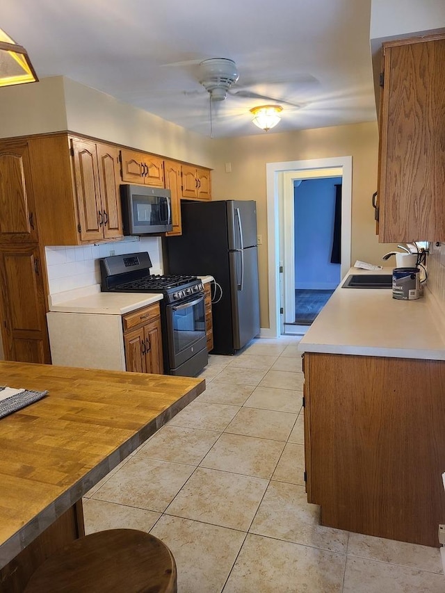 617 E Morgan St, Dixon, IL 61021 - kitchen with stainless steel appliances, a sink, light countertops, a ceiling fan, and light tile patterned flooring