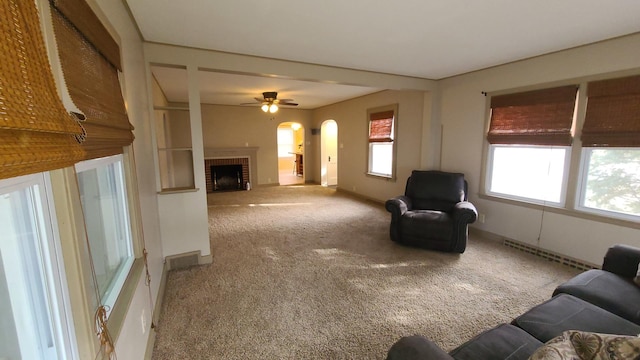 617 E Morgan St, Dixon, IL 61021 - carpeted living room with arched walkways, baseboards, a fireplace, and a ceiling fan