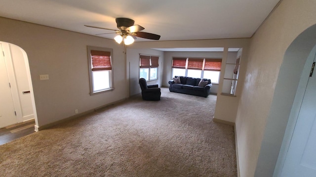 617 E Morgan St, Dixon, IL 61021 - carpeted living room featuring arched walkways, a ceiling fan, and baseboards