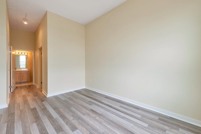 empty room with a high ceiling and light hardwood / wood-style floors