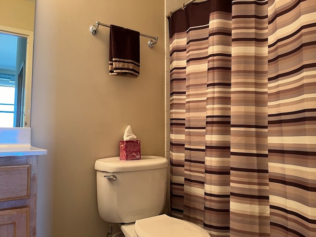 bathroom featuring a shower with shower curtain, vanity, and toilet