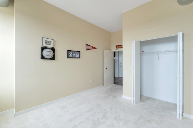 unfurnished bedroom featuring light colored carpet and a closet