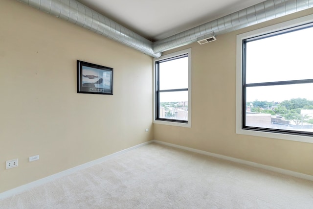 spare room featuring light carpet and a healthy amount of sunlight