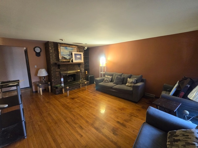 living room featuring hardwood / wood-style flooring and a brick fireplace