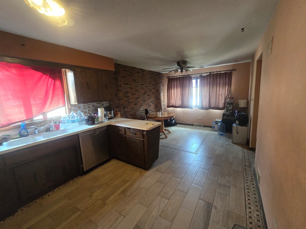 kitchen featuring stainless steel dishwasher, light wood-type flooring, sink, and a healthy amount of sunlight