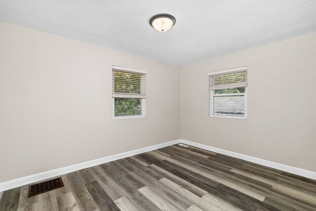 unfurnished room featuring dark hardwood / wood-style flooring and plenty of natural light