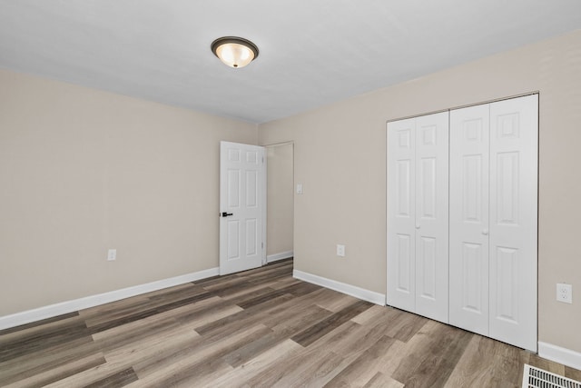 unfurnished bedroom with hardwood / wood-style flooring and a closet