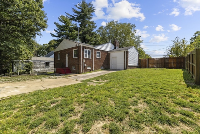 exterior space featuring an outbuilding, a garage, a patio, and a front lawn