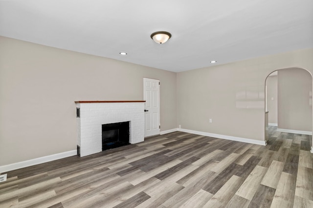 unfurnished living room with a fireplace and wood-type flooring