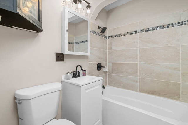 full bathroom featuring vanity, toilet, and tiled shower / bath combo