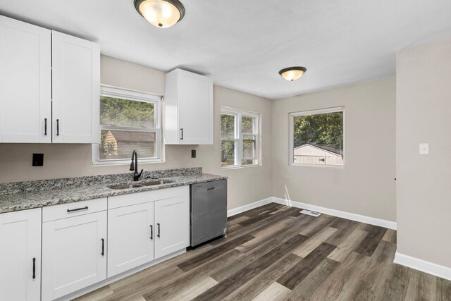 kitchen with light stone counters, white cabinetry, sink, dark wood-type flooring, and stainless steel dishwasher