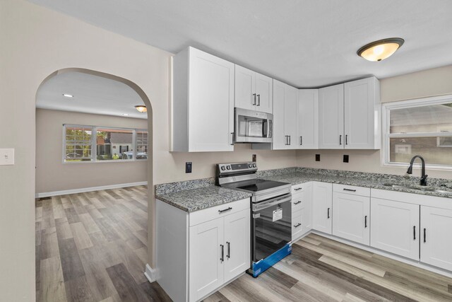 kitchen featuring light hardwood / wood-style flooring, stainless steel appliances, sink, and white cabinets