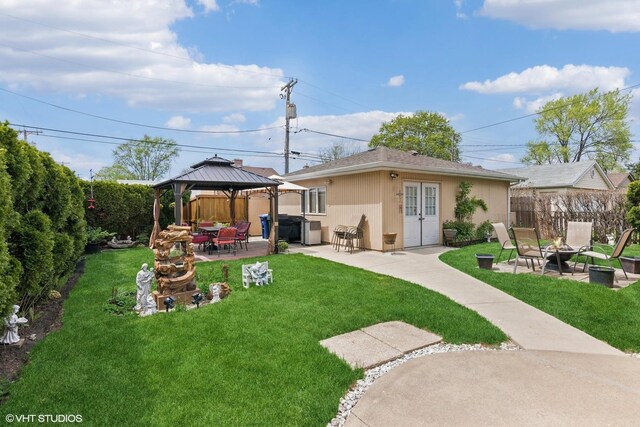 back of property with a fire pit, a gazebo, a patio, and french doors