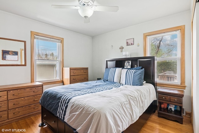 bedroom featuring wood finished floors, ornamental molding, and a ceiling fan