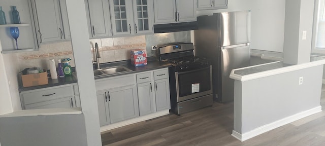 kitchen featuring decorative backsplash, stainless steel appliances, sink, and dark hardwood / wood-style flooring