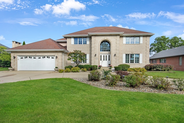 view of front of property featuring a garage and a front lawn