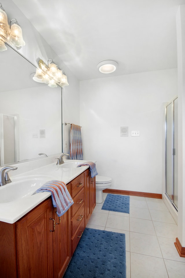 bathroom featuring tile patterned flooring, a shower with shower door, vanity, and toilet