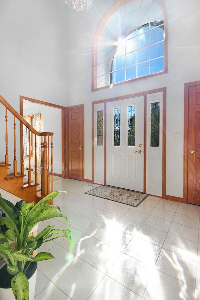 tiled entrance foyer with a towering ceiling