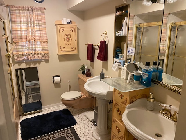 bathroom featuring an enclosed shower, toilet, and sink