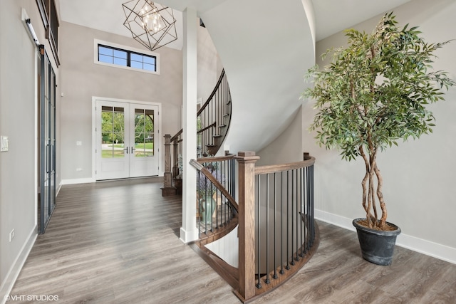 entryway featuring french doors, an inviting chandelier, dark hardwood / wood-style floors, and high vaulted ceiling