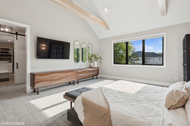 carpeted bedroom featuring vaulted ceiling with beams, multiple windows, a walk in closet, and a barn door