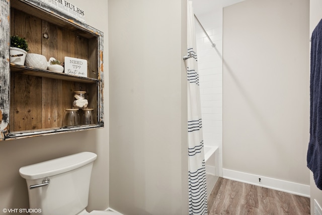 bathroom with shower / bath combo, hardwood / wood-style floors, and toilet