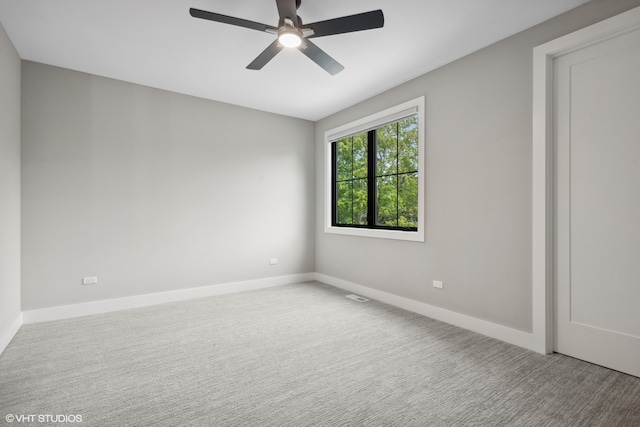 carpeted spare room featuring ceiling fan