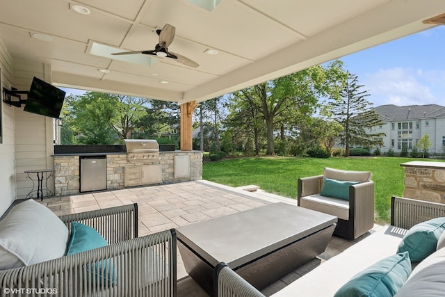 view of patio with area for grilling, outdoor lounge area, ceiling fan, and an outdoor kitchen