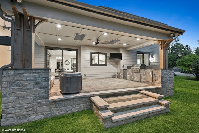 back of house featuring a patio, a yard, ceiling fan, and exterior kitchen