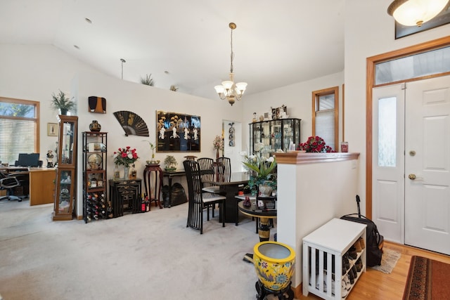 carpeted dining area with vaulted ceiling and an inviting chandelier