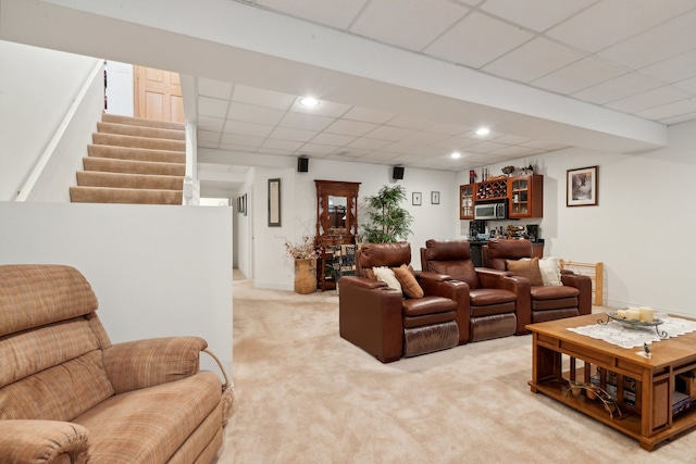 carpeted living room with a drop ceiling