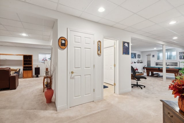 interior space featuring a paneled ceiling and light colored carpet