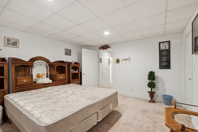 bedroom with light colored carpet and a paneled ceiling