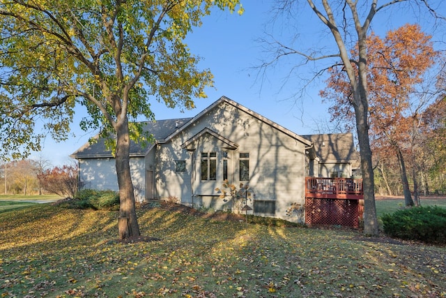 view of side of home featuring a yard and a deck