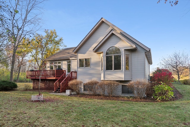 rear view of property featuring a lawn and a deck