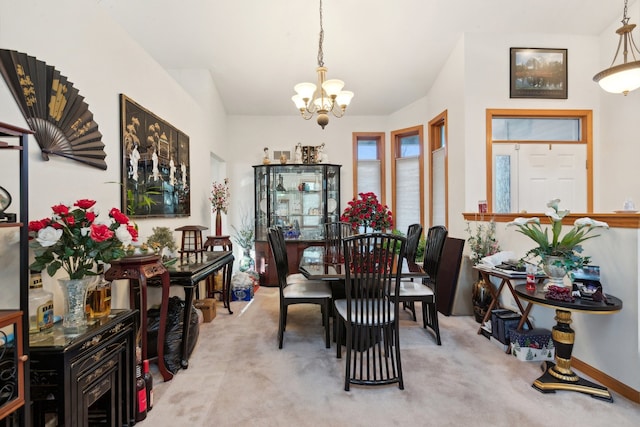 carpeted dining area featuring a notable chandelier