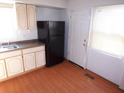 kitchen with light hardwood / wood-style flooring, sink, and black fridge