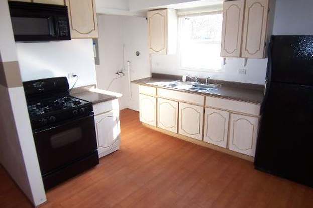 kitchen featuring light wood-type flooring, black appliances, and sink