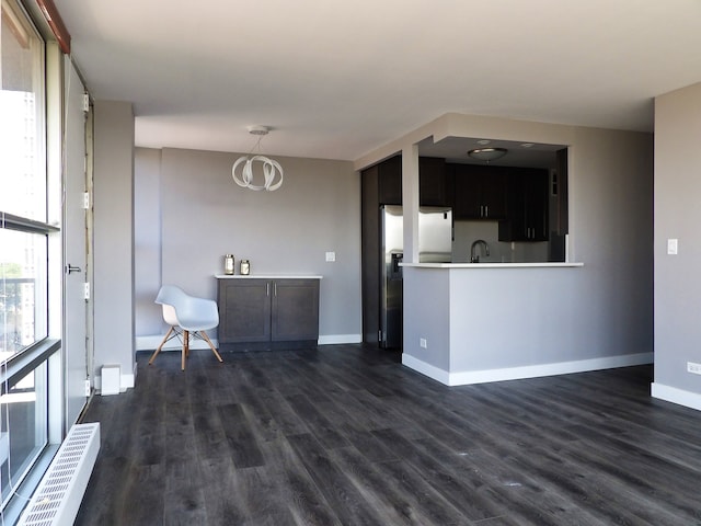 kitchen with dark wood-type flooring, fridge, and kitchen peninsula