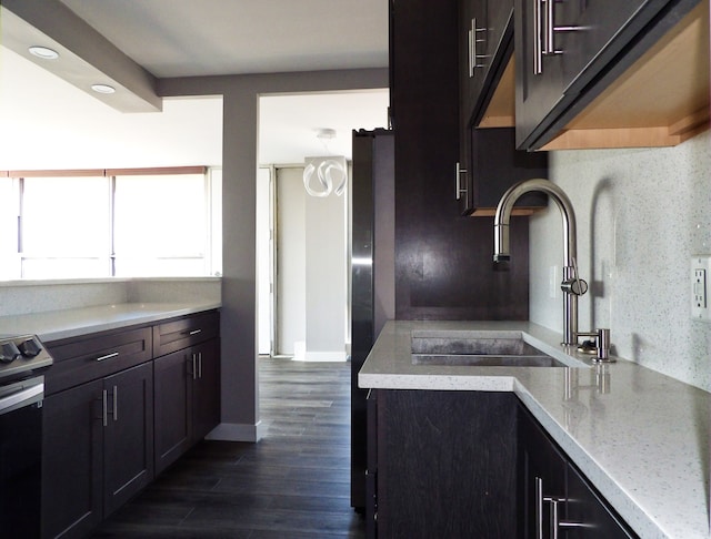 kitchen featuring dark hardwood / wood-style flooring, dark brown cabinets, sink, and light stone counters