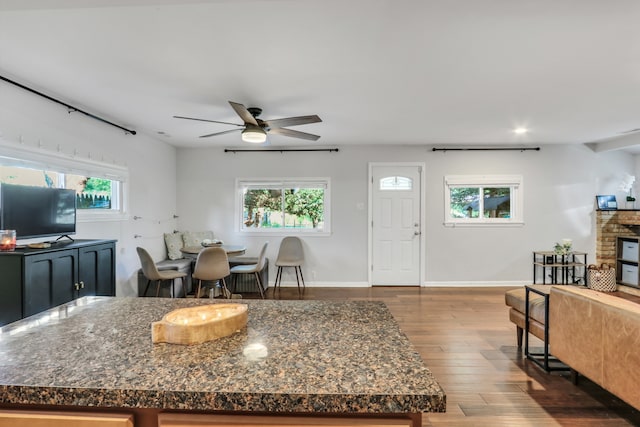 kitchen featuring plenty of natural light, ceiling fan, and a brick fireplace