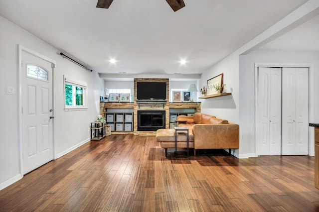 living room featuring a fireplace, hardwood / wood-style floors, and ceiling fan