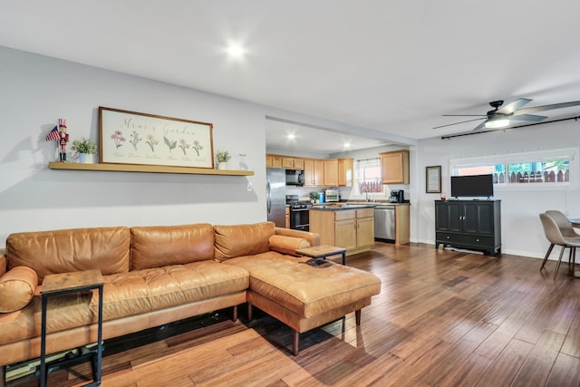 living room with dark hardwood / wood-style flooring, a healthy amount of sunlight, sink, and ceiling fan