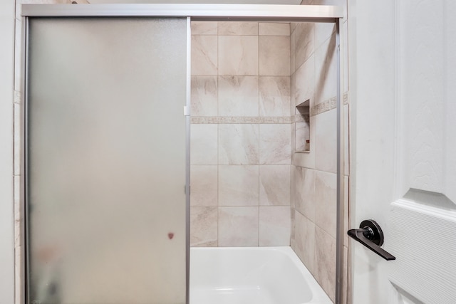 bathroom with shower / bath combination with glass door