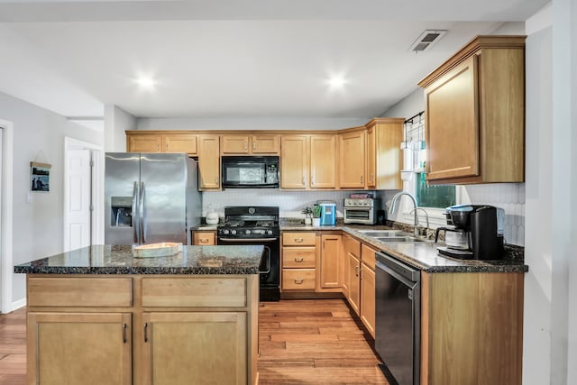 kitchen featuring light wood-type flooring, black appliances, and a center island