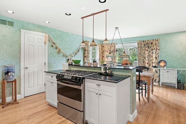 kitchen with white cabinetry, light wood-type flooring, pendant lighting, a center island, and stainless steel gas range