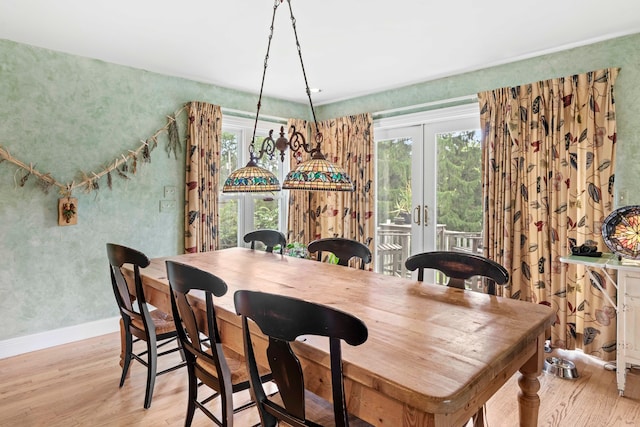 dining room featuring french doors and light hardwood / wood-style flooring