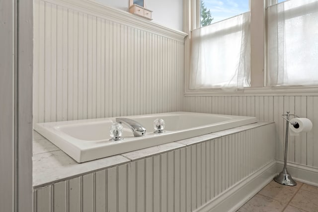 bathroom with a tub and tile patterned floors