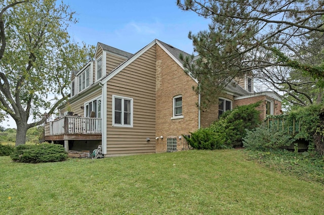 rear view of property featuring a deck and a lawn